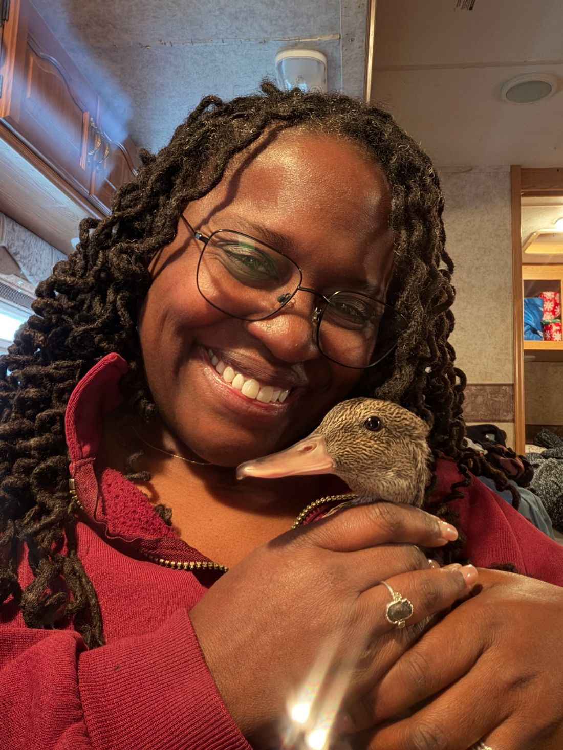 Peggy the duck tucked against Dr. Atkinson-Spinks, who is smiling at the camera